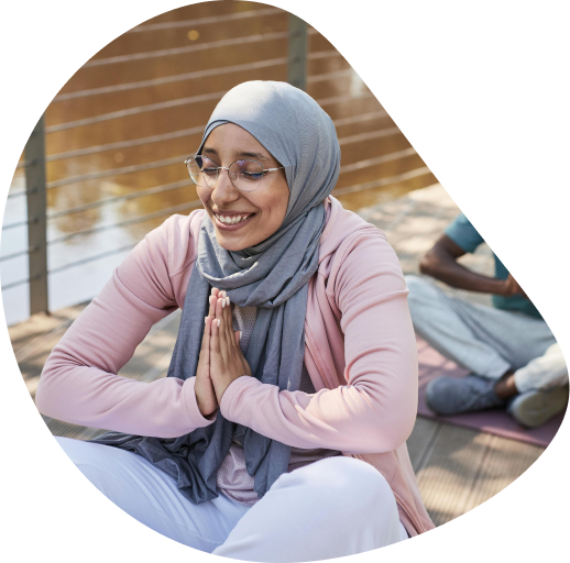 Woman doing yoga in a big room wearing yoga clothing